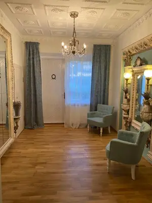 a living room with a chair and a mirror at Petro Apartamentai in Kačerginė