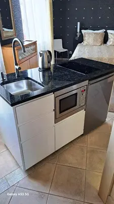 a kitchen counter with a sink and a microwave at KaunasInn in Kaunas