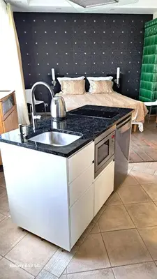 a kitchen with a sink and a bed in a room at KaunasInn in Kaunas