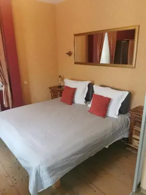 a bedroom with a white bed with red pillows at KaunasInn in Kaunas