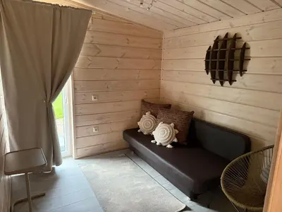 a room with a couch in a log cabin at Obuoliu Sala OLAGA on the Apple Island in Gaylyunay