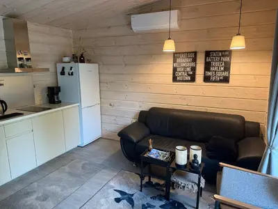 a living room with a couch and a kitchen at Obuoliu Sala OLAGA on the Apple Island in Gaylyunay