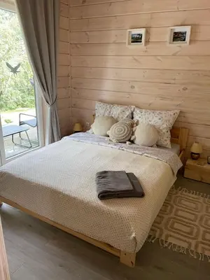 a bedroom with a bed and a large window at Obuoliu Sala OLAGA on the Apple Island in Gaylyunay