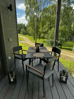 a table and chairs on the porch of a house at Obuoliu Sala OLAGA on the Apple Island in Gaylyunay