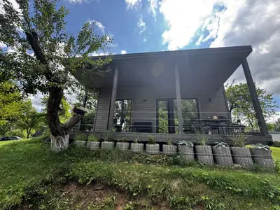 a house on a hill with a tree at Obuoliu Sala OLAGA on the Apple Island in Gaylyunay