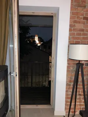 a door with a view of a balcony at night at Charming Apartment in Kaunas Old Town with Balcony in Kaunas
