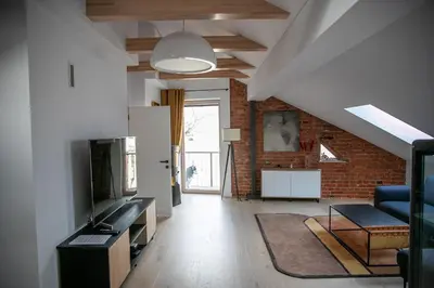 an attic living room with a brick wall at Charming Apartment in Kaunas Old Town with Balcony in Kaunas