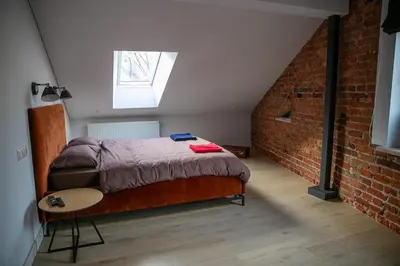 a bedroom with a bed and a brick wall at Charming Apartment in Kaunas Old Town with Balcony in Kaunas