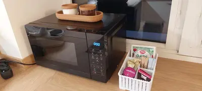 a microwave oven with a basket on top of it at DIVA contactless check in & out in Šiauliai