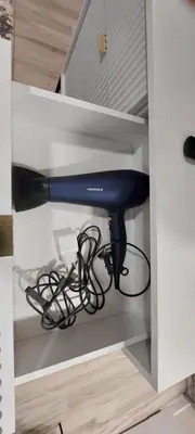 a blue hair dryer sitting inside of a cabinet at DIVA contactless check in & out in Šiauliai