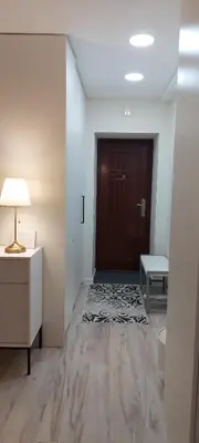 a hallway with a door and a table and a lamp at DIVA contactless check in & out in Šiauliai