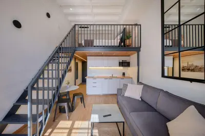 a living room with a couch and a kitchen at Queen Barbora Central Lofts in Kaunas