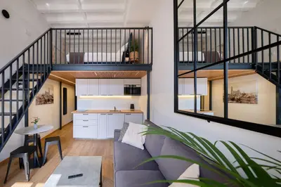 a living room with a couch and a kitchen at Queen Barbora Central Lofts in Kaunas