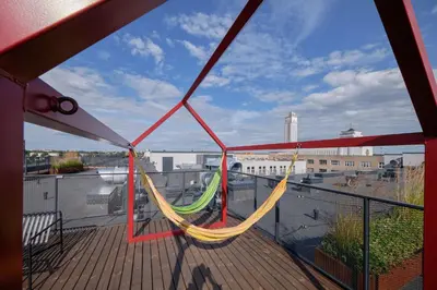 a balcony with a hammock on a deck at Queen Barbora Central Lofts in Kaunas