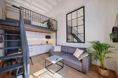a living room with a couch and a staircase at Queen Barbora Central Lofts in Kaunas