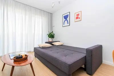 a large bed in a room with a table at 1bdr Apt w/Balcony, free Pkg in Vilnius