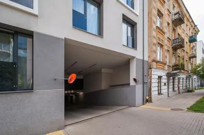 a building with an open garage on a street at 1bdr Apt w/Balcony, free Pkg in Vilnius