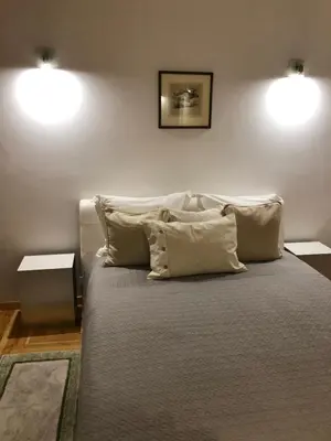 a bedroom with a large bed with two lights on the wall at KaunasInn - AM in Kaunas