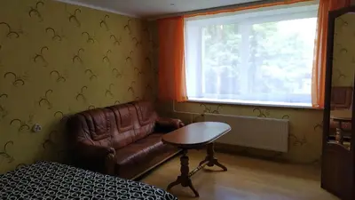 a living room with a leather couch and a table at Visaginas Taikos 84 in Visaginas