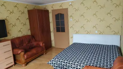 a bedroom with a bed and a leather couch at Visaginas Taikos 84 in Visaginas