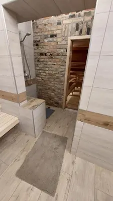 a bathroom with a shower and a brick wall at Fun and chill patalpu ir pirties nuoma in Vilnius