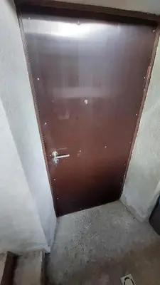 a brown door in a room with a concrete floor at Fun and chill patalpu ir pirties nuoma in Vilnius