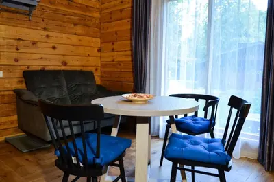 a table and four chairs in a room with a window at Hotel resort Sedula in Skogalis