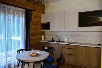 a kitchen with a table and a sink and a counter at Hotel resort Sedula in Skogalis