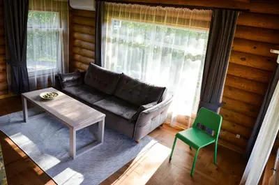 a living room with a couch and a table and a chair at Hotel resort Sedula in Skogalis