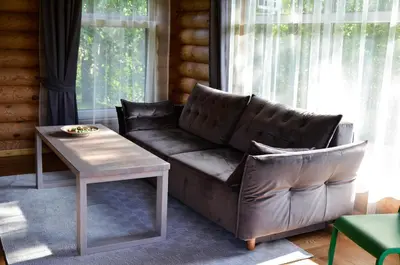 a living room with a leather couch and a table at Hotel resort Sedula in Skogalis