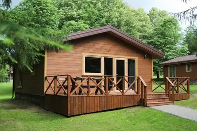 a small cabin with a porch and a deck at Hotel resort Sedula in Skogalis