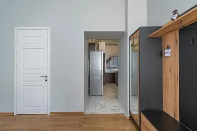 a hallway with a white door and a refrigerator at Prestigious city center apartment with free parking by Polo Apartments in Kaunas