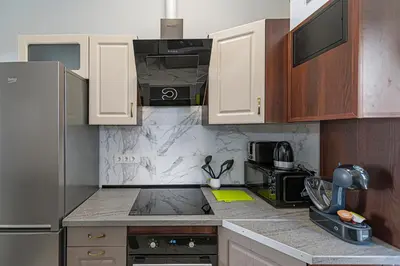 a kitchen with wooden cabinets and a stove top oven at Prestigious city center apartment with free parking by Polo Apartments in Kaunas