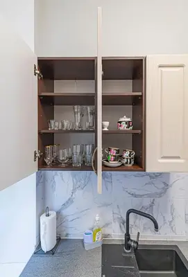 a kitchen with white cabinets and a sink at Prestigious city center apartment with free parking by Polo Apartments in Kaunas