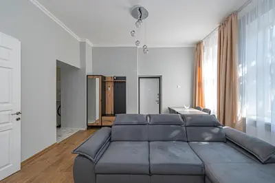 a living room with a couch and a large window at Prestigious city center apartment with free parking by Polo Apartments in Kaunas