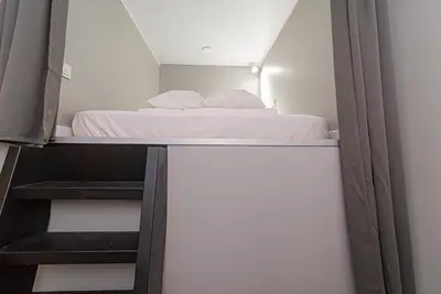 a small bedroom with a bed and some stairs at Secret SPA in Vilnius