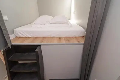 a bed in a small room with a mirror at Secret SPA in Vilnius