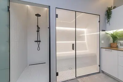 a glass shower door in a bathroom with a tub at Secret SPA in Vilnius