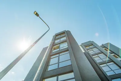 a tall building with the sun in the sky at Butas su Jacuzzi Kauno miesto centre in Kaunas