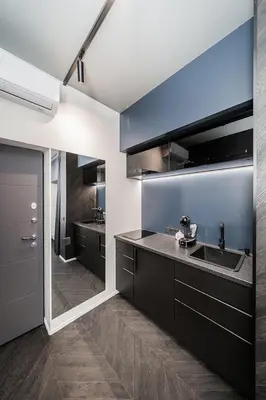 a kitchen with black cabinets and a sink at Butas su Jacuzzi Kauno miesto centre in Kaunas