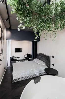 a bedroom with a bed with plants on the wall at Butas su Jacuzzi Kauno miesto centre in Kaunas