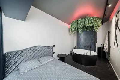 a bedroom with a bed and a bath tub at Butas su Jacuzzi Kauno miesto centre in Kaunas