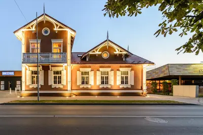 a large orange building with a balcony on a street at Vila Arnika in Druskininkai