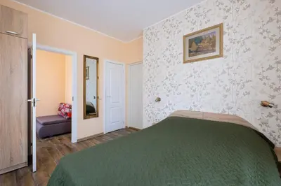 a bedroom with a green bed in a room at Vila Arnika in Druskininkai