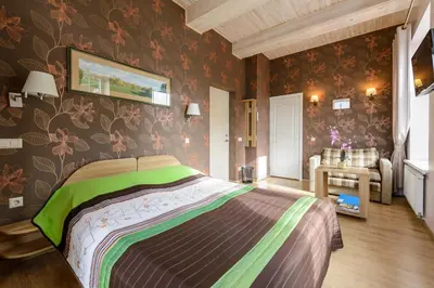 a bedroom with a large bed with floral wallpaper at Vila Arnika in Druskininkai