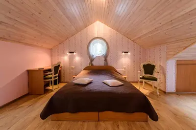 a bedroom with a bed and a desk and a window at Vila Arnika in Druskininkai