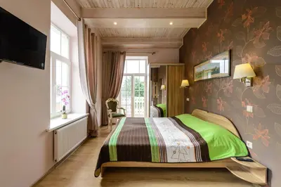 a bedroom with a bed with a green blanket at Vila Arnika in Druskininkai