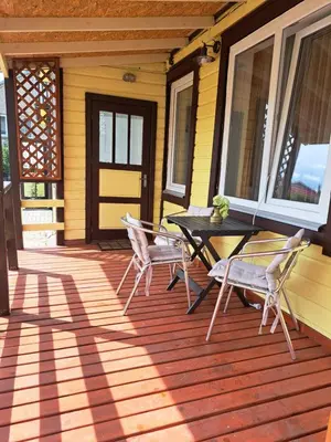 a patio with a table and chairs on a house at Vasarnamis Zarasuose - Vyšnia in Zarasai
