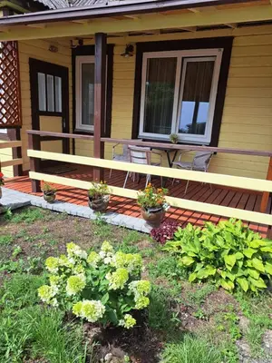 a porch of a house with a bench and some plants at Vasarnamis Zarasuose - Vyšnia in Zarasai