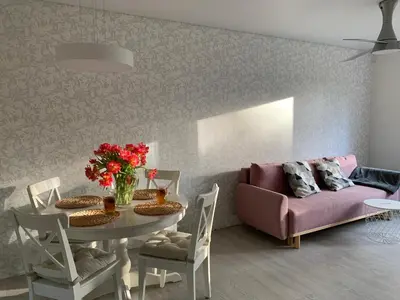 a living room with a table and a couch at Palūšės Apartment in Palūšė